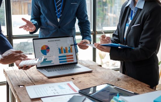 Business team analyzing income charts and graphs with modern laptop computer. Business analysis and strategy concept.